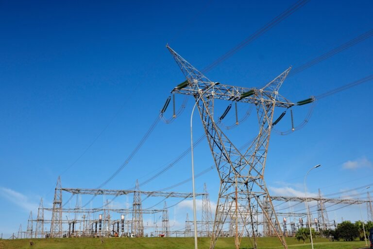 Com muita disputa, Aneel leiloou oito lotes de transmissão de energia 6 leilao da aneel: Torres de alta tensão e subestação de energia elétrica sob céu azul.