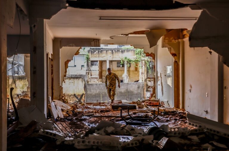 Rio Uruguai está em elevação e atinge cota de alerta em Uruguaiana 4 cota de alerta: Militar fardado caminha por entre escombros e lama no interior de um prédio destruído.