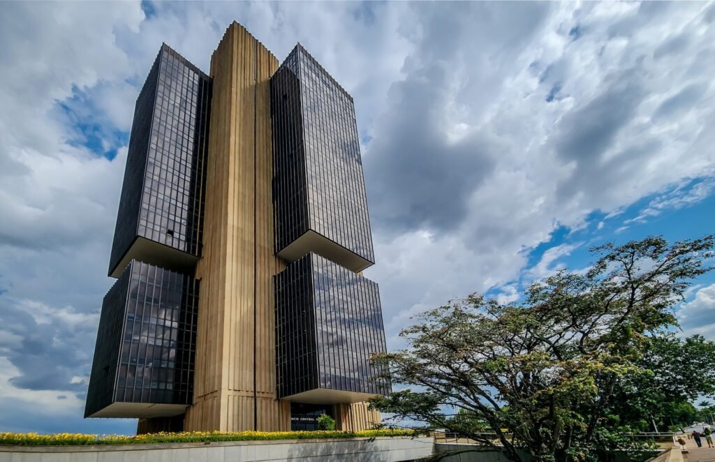 IBC-Br: Edifício do Banco Central do Brasil em Brasília, com arquitetura moderna de vidro e concreto sob céu nublado.