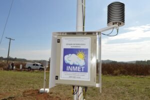 alerta do Inmet: estação meteorológica automática instalada em campo com placa informativa e sensores.